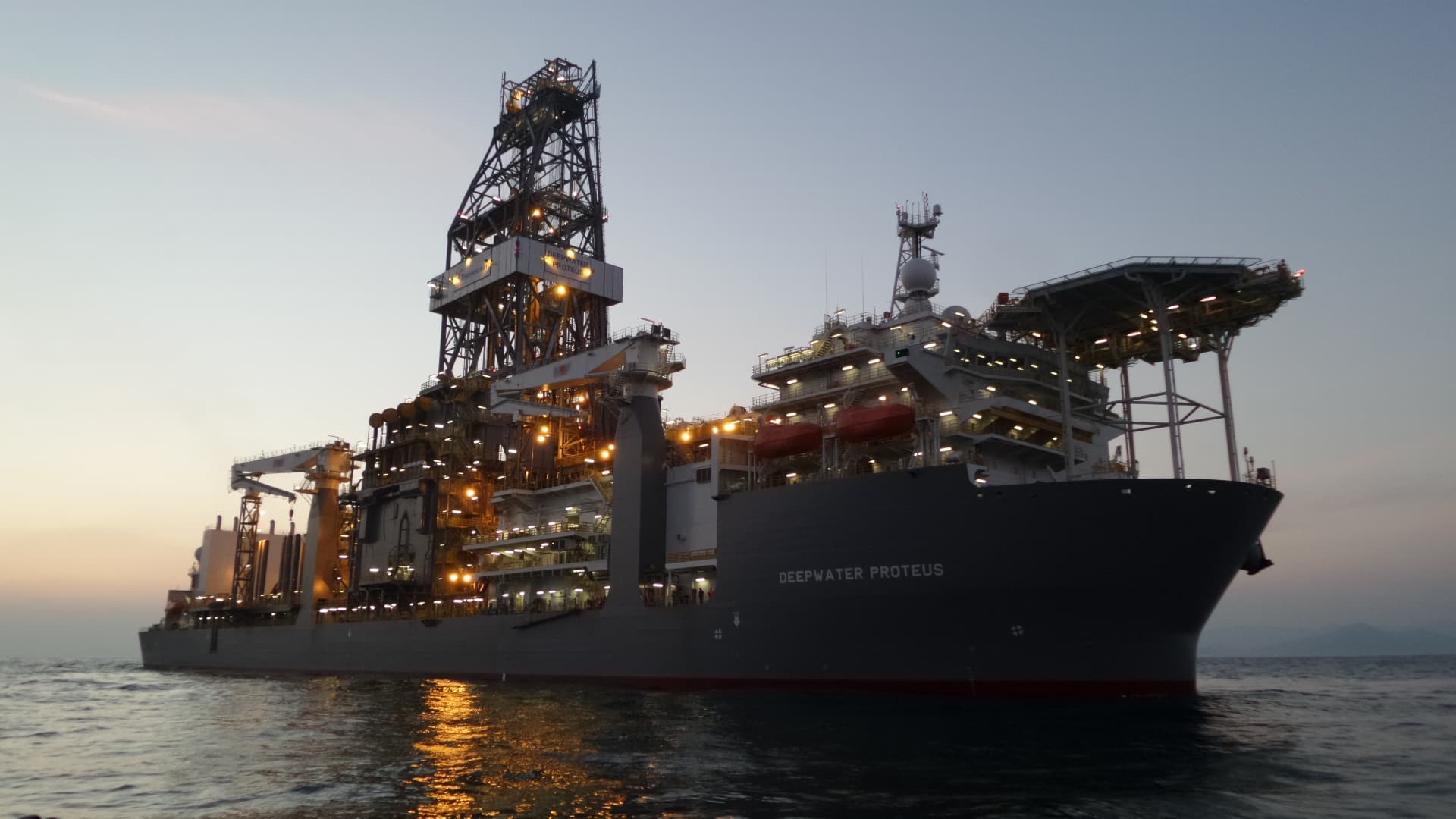 The drillship Deepwater Proteus illuminated at dusk